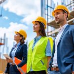 Diverse professionals collaborating on a construction site, representing strategic financing approaches for construction projects.