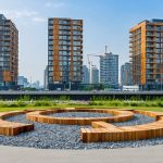 Architectural skyline showcasing buildings constructed with sustainable materials like modular timber, recycled steel, and repurposed concrete, representing the circular economy in modern construction.